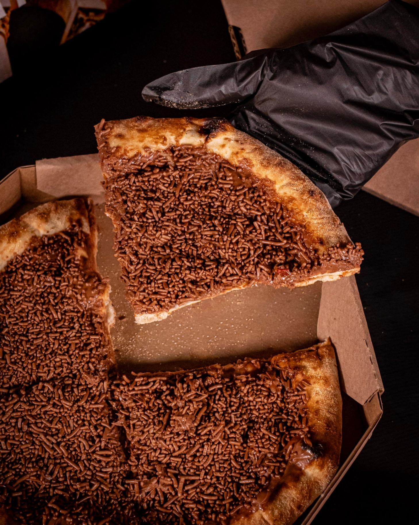 Broto doce de brigadeiro com granulado saindo da caixa